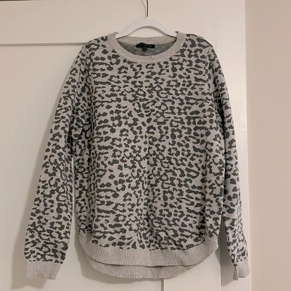 Crewneck gray on gray leopard print sweater with ribbed edge detail.